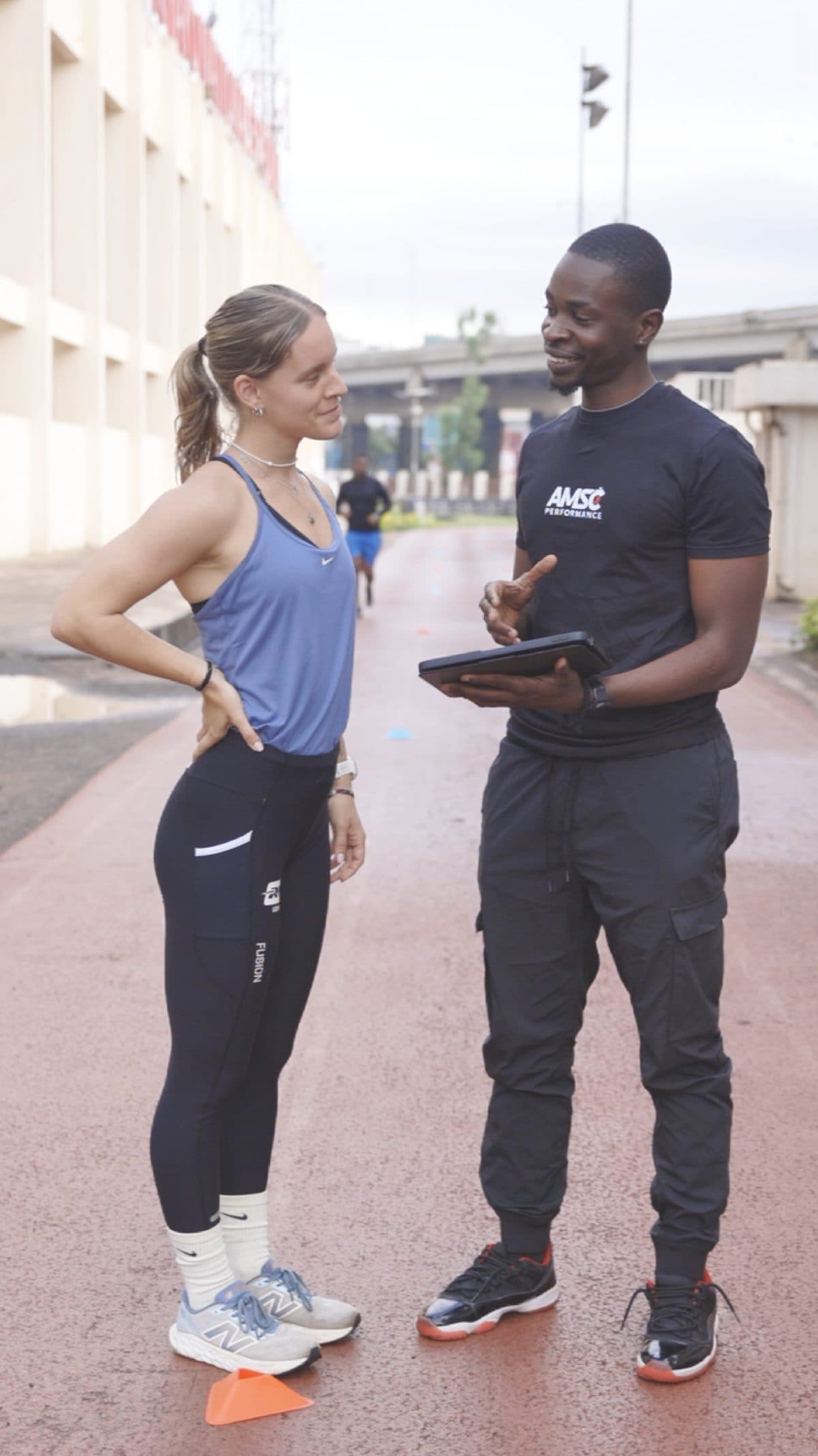 AMSC coach reviewing athlete data on track